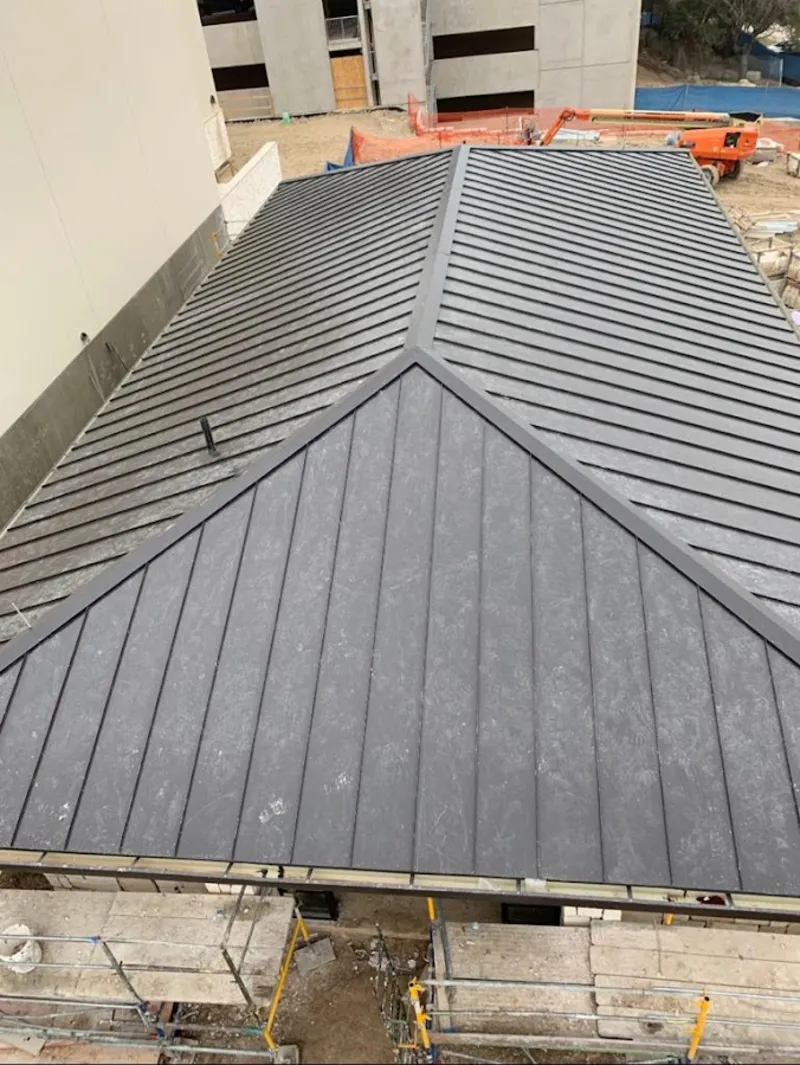 Commercial metal roof construction with crane equipment in Oregon